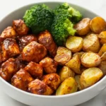 Easy Mediterranean Skinny Chicken and Roasted Potato Bowl with fresh veggies, feta cheese, and a light lemon dressing.