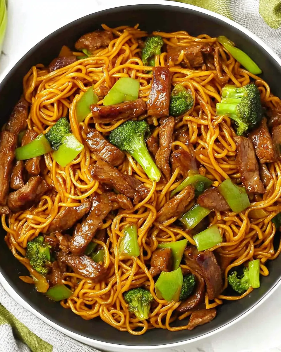 Sticky Beef Noodles with tender beef, savory sauce, and fresh vegetables in a bowl.