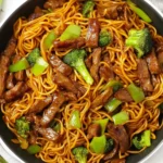 Sticky Beef Noodles with tender beef, savory sauce, and fresh vegetables in a bowl.