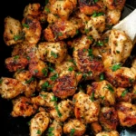 Close-up photo of juicy 15-Minute Garlic Butter Chicken Bites served in a skillet, garnished with fresh parsley and golden seared edges.