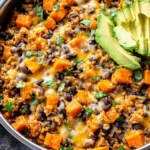 Southwest Sweet Potato, Black Bean, and Rice Skillet with corn and avocado garnish