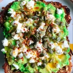 Avocado Feta Toast plated on rustic kitchen table