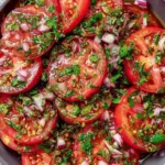 Marinated tomato salad with fresh herbs in a white bowl