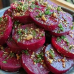 Thinly sliced garlic butter roasted beets on a white plate