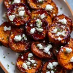 Honey-drizzled sweet potato rounds topped with whipped feta and herbs on a serving tray