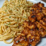 Creamy lemon garlic butter chicken served over parmesan pasta in a white bowl