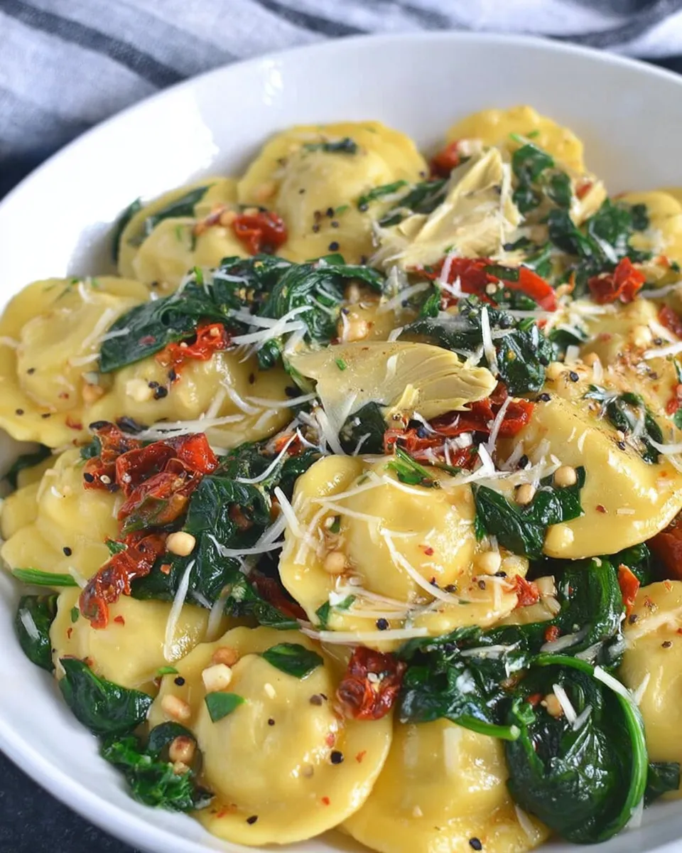 Cheese ravioli with spinach, sun-dried tomatoes, and artichokes on a plate