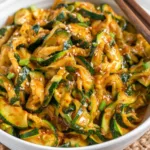 Chinese-style zucchini stir-fry with garlic and red chili flakes on a white plate