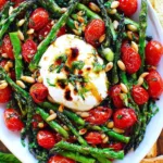 Asparagus tomato salad with burrata cheese and basil on a white plate