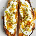 Burrata toast with pistachios and hot honey on rustic bread