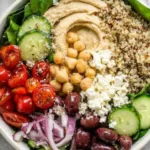 Mediterranean hummus bowl with veggies, olives, and pita