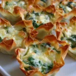 Golden baked spinach and artichoke wonton cups in muffin tin