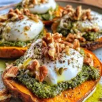 Stuffed sweet potatoes with burrata, toasted walnuts, and sage pesto on a serving plate