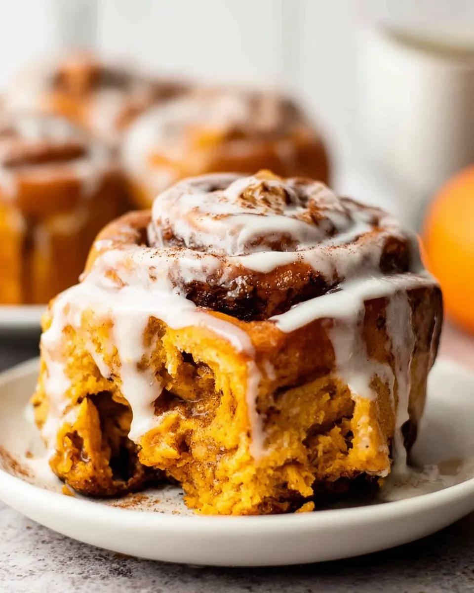 Pumpkin cinnamon rolls served on fall brunch table with cider