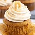 Pumpkin cupcakes topped with cream cheese frosting and cinnamon dust
