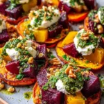 Sweet potato rounds topped with burrata, roasted beets, and mint yogurt drizzle on a serving platter.