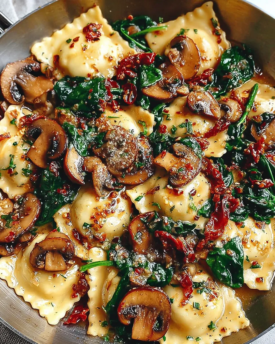 Cheesy ravioli with spinach, mushrooms, and sun-dried tomatoes served on a plate