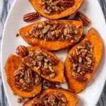 Maple garlic butter sweet potatoes with toasted pecans on rustic baking tray
